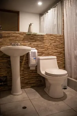 a bathroom with a toilet and a sink at Home Garden Hotel in Cusco