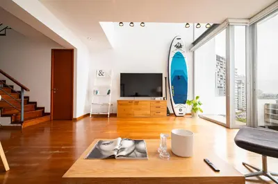 a living room with a tv and a table at InkaHuset Miraflores Oceanfront in Lima