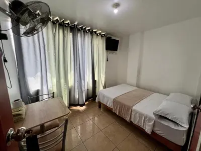 a small bedroom with a bed and a window at Hospedaje Senegal cerca al aeropuerto in Lima