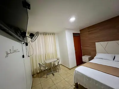 a bedroom with a bed and a table and chairs at Hospedaje Senegal cerca al aeropuerto in Lima