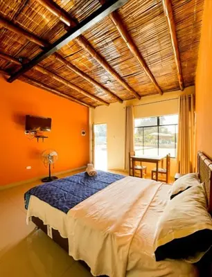 a bedroom with a large bed and a large window at Hospedaje La Huega in Ica