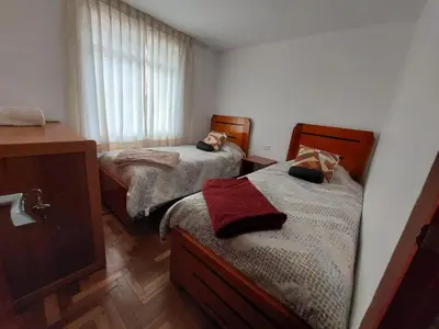 a small bedroom with two beds and a window at Mandalas Cusco in Cusco