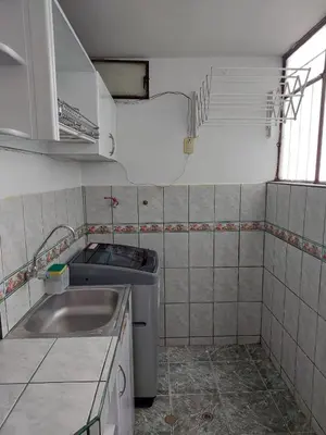 a small kitchen with a sink and a washer at Pawllu Inqa Lodge in Cusco