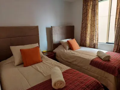 a bedroom with two beds with pillows and a window at Pawllu Inqa Lodge in Cusco