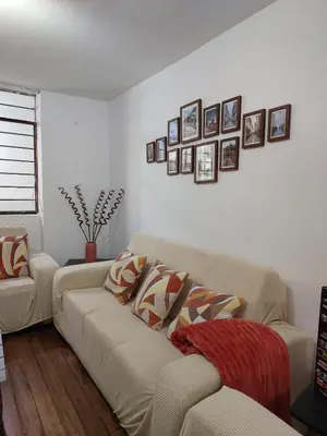 a living room with a couch and pictures on the wall at Pawllu Inqa Lodge in Cusco