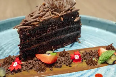a piece of chocolate cake on a blue plate at Holiday Inn - Lima Miraflores by IHG in Lima
