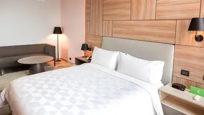 a bedroom with a large white bed and a chair at Holiday Inn - Lima Miraflores by IHG in Lima