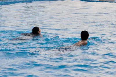 two people swimming in a body of water at Casa Andina Select Paracas in Paracas