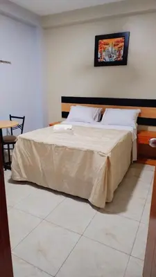 a bedroom with a large bed with a wooden headboard at Hostal Parisuite in Lima