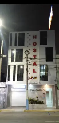 a white building with a sign on it at night at Hostal Parisuite in Lima