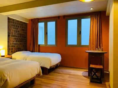 a hotel room with two beds and two windows at 1911 in Machu Picchu