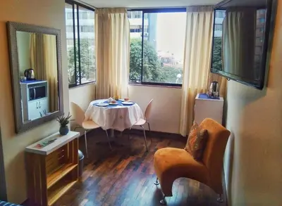 a living room with a table and a television at Amplia habitación con baño in Lima