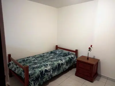 a bedroom with a bed and a wooden night stand at Sucesac in Lima