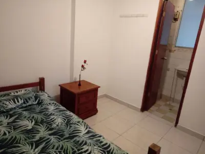 a bedroom with a bed and a bathroom with a shower at Sucesac in Lima