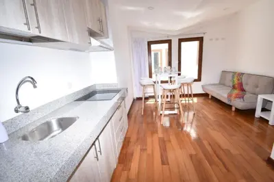a kitchen with a sink and a living room at Katari Apart Hotel at Qorikancha in Cusco