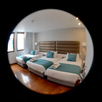 a room with three beds with blue pillows at Katari Apart Hotel at Qorikancha in Cusco