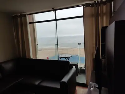 a living room with a couch and a large window at Blue Coast Lima apart Peru in Lima