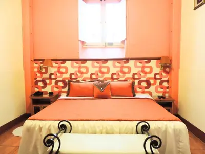 a bedroom with a large bed with an orange headboard at Lima Wari Hotel Boutique in Lima