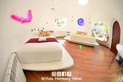 a bedroom with a large bed in a room with windows at Wifala Harmony Hotel in Urubamba