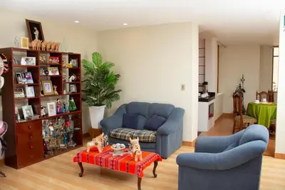 a living room with two blue couches and a table at Allin Illary Eco Hospedaje in Urubamba