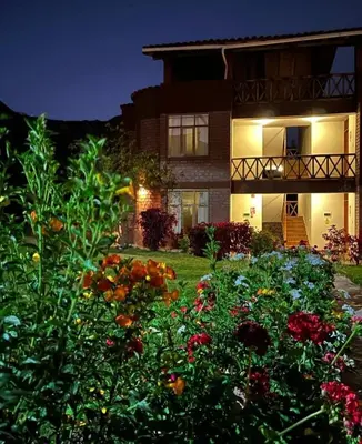 a house with a garden of flowers in front of it at Allin Illary Eco Hospedaje in Urubamba