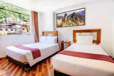 a hotel room with two beds and a window at Hotel Machupicchu Inn in Machu Picchu