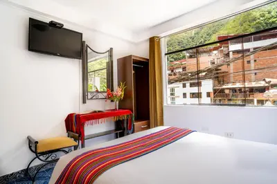 a bedroom with a bed and a large window at Hotel Machupicchu Inn in Machu Picchu
