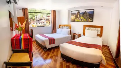 a hotel room with two beds and a window at Hotel Machupicchu Inn in Machu Picchu