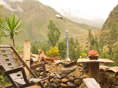 a view of a mountain with a dog sitting on a bench at Casa Patacalle in Ollantaytambo