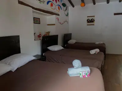 a room with two beds in a room at Casa Patacalle in Ollantaytambo