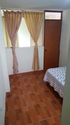 a room with a bed and a window and a wooden floor at Hospedaje Arana in Chincha Alta