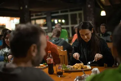 a woman sitting at a table eating a plate of food at Hotel Puerto Inka in Chala