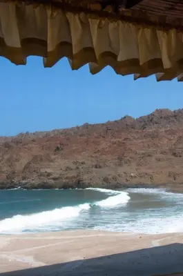 a beach with a wave in the ocean at Hotel Puerto Inka in Chala