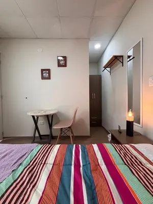 a room with a bed and a table and a chair at Casa de Juan y Violeta in Lima