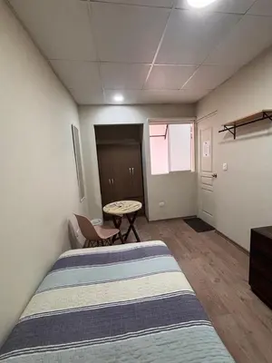 a room with a bed and a table in it at Casa de Juan y Violeta in Lima