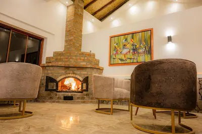 a living room with two chairs and a fireplace at Llamita Hotel-Huancayo in Huancayo