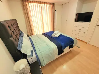 a bedroom with a bed and a dresser and a television at Fiflos Apartament in Cusco