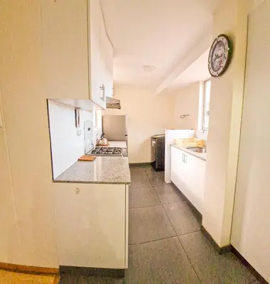 a kitchen with white cabinets and a counter top at Fiflos Apartament in Cusco