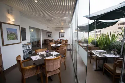 a restaurant with tables and chairs and an umbrella at Tierra Viva Miraflores Larco in Lima