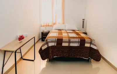 a small bedroom with a bed and a desk at Keylas Hotel in Ica