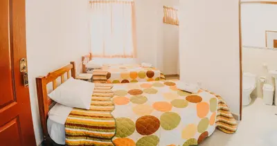 two beds in a room with a mirror at Keylas Hotel in Ica