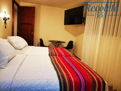 a bedroom with a bed with a colorful blanket on it at Casa Durand in Cusco