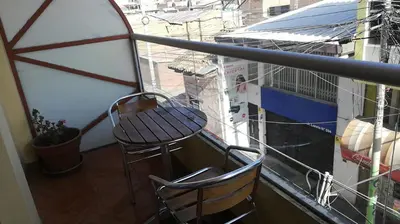 a balcony with a table and a chair on a ship at CasaHotel Centro - Huancayo in Huancayo
