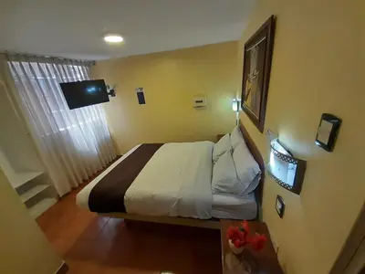 a hotel room with a bed and a table at CasaHotel Centro - Huancayo in Huancayo
