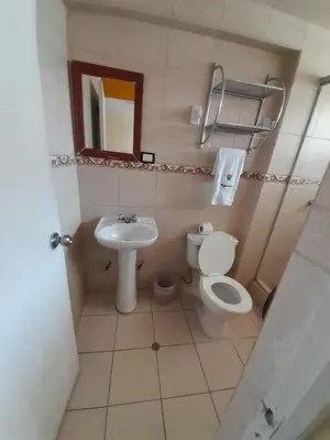 a small bathroom with a toilet and a sink at CasaHotel Centro - Huancayo in Huancayo