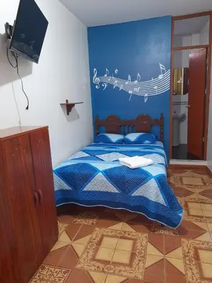 a bedroom with a bed with a blue wall at Nasca Trails B&B in Nazca