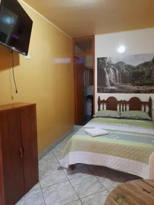 a bedroom with a bed and a flat screen tv at Nasca Trails B&B in Nazca