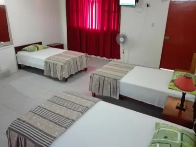 a room with two beds and a red curtain at Nasca Trails B&B in Nazca