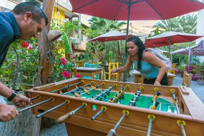 a man and a woman playing a game of billiard at Banana's Adventure Hostel in Ica