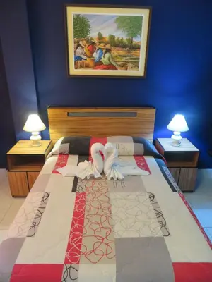 a bedroom with a bed with two lamps on it at Hostal Hellen Ross in Nazca